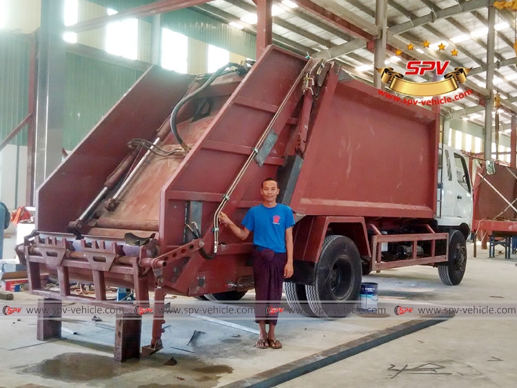 Myanmar workers with half-finished garbage truck